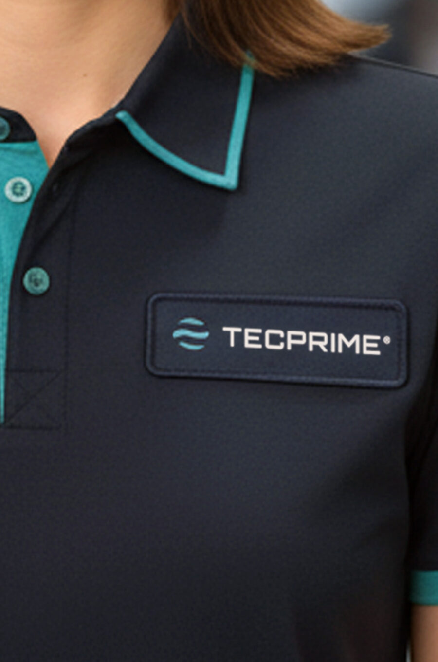 Person wearing a TECPRIME branded polo shirt in a modern office, representing customer support and contact services.